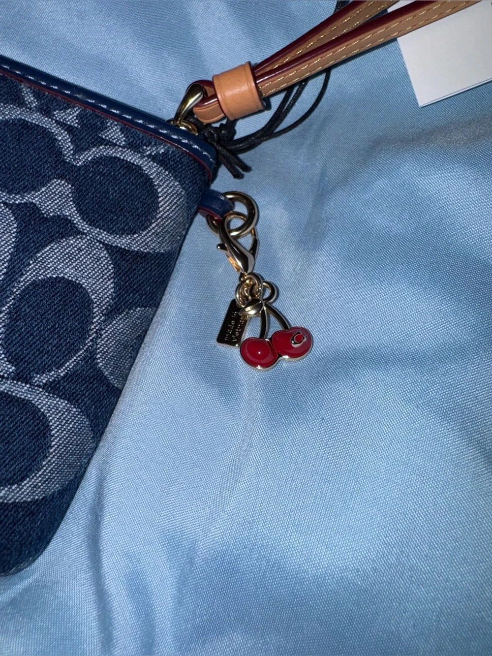 Coach Signature Denim Wristlet in Navy with Brown Leather Strap and cherry charm